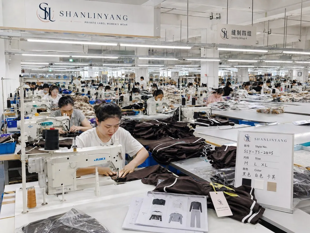 Shanlinyang Apparel sewing floor in Xiamen operators at JUKI machines producing a custom tracksuit order